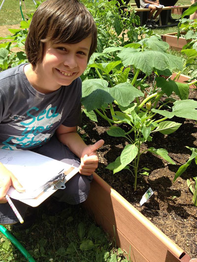 boy smiling next to plants