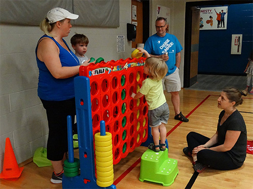 Kids playing at the Regional YMCA of Western CT with a Giant Connect Four in the Gym