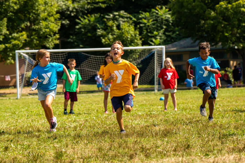 kids running on a field at Summer Camp