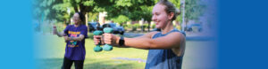 Woman holding exercise weights outside. Join woth zero Joiner's fee when you join May 16-31.