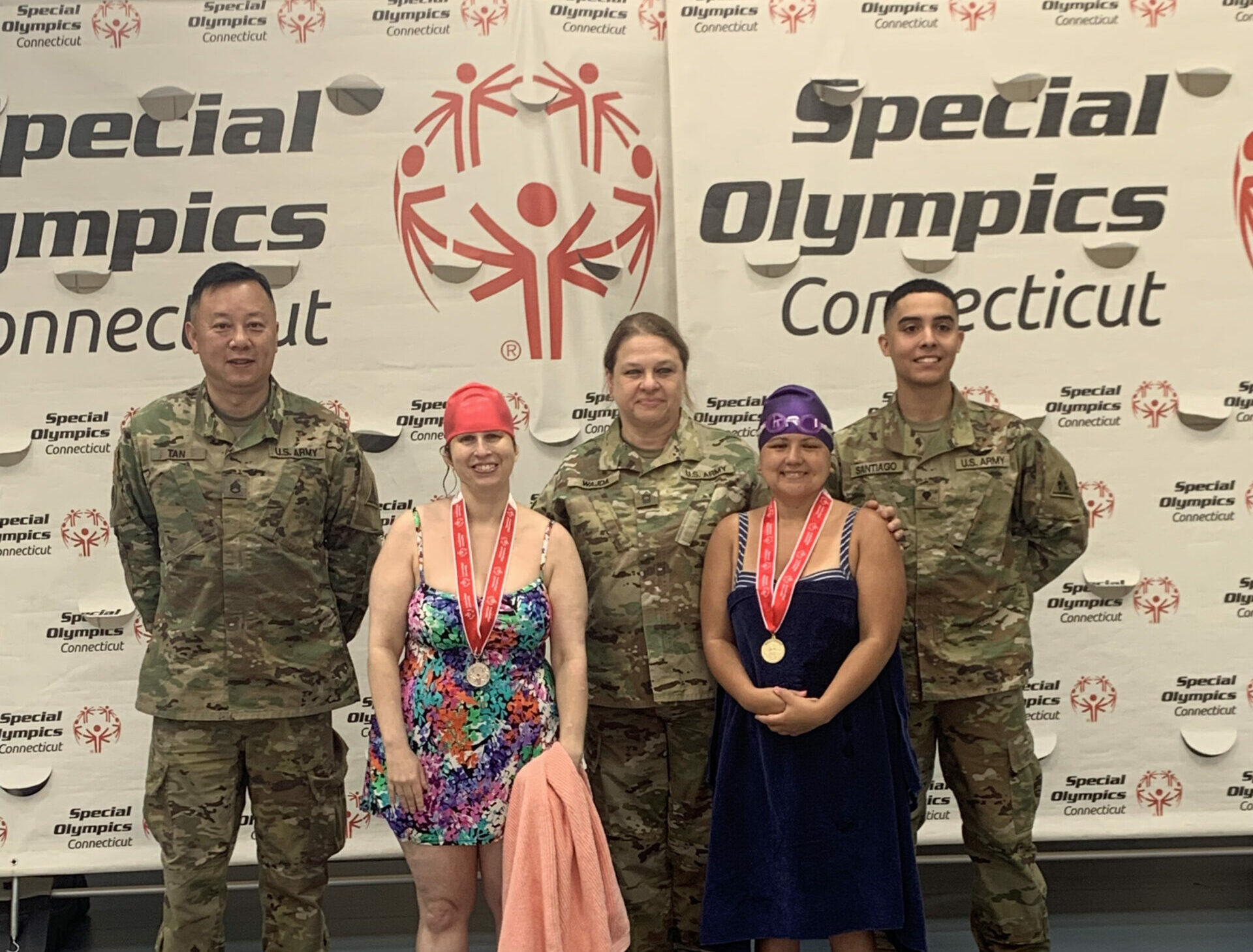 Maleigha on left at Special Olympics awards ceremony with 3 military soldiers with her