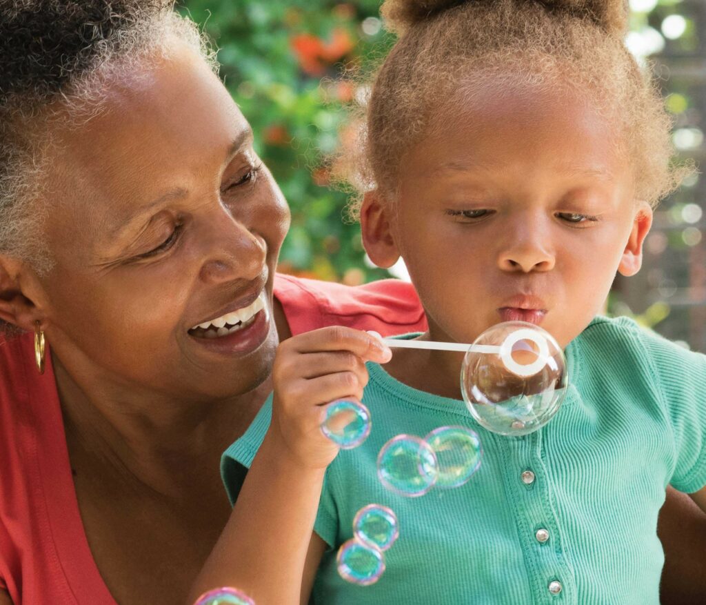 Grandmother with granddaughter blowing bubbles